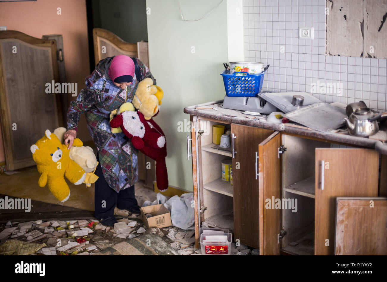 Gaza Stadt, dem Gazastreifen, Israel. 15 Nov, 2018. Eine Palästinenserin in einem Kindergarten arbeiten gesehen, Puppen, während neben den Ruinen von einem Gebäude, das während des israelischen Luftangriff in Gaza zerstört wurde. Ein Waffenstillstand wurde nach dem schlimmsten Eskalation zwischen Israel und dem Gazastreifen Aktivisten seit einem Krieg 2014 statt, aber die Situation blieb volatil und das Abkommen löste scharfe Meinungsverschiedenheiten innerhalb der israelischen Regierung. Credit: Mahmoud Issa/SOPA Images/ZUMA Draht/Alamy leben Nachrichten Stockfoto