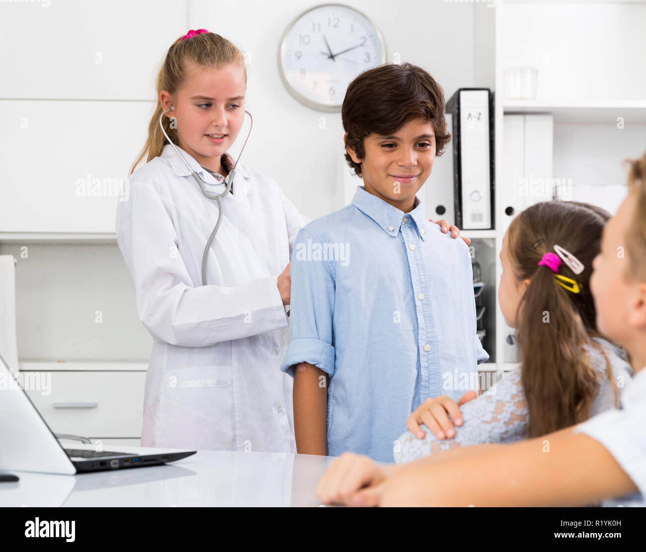 Medic Mädchen mit Stethoskop mit jungen Patienten in der Arztpraxis Stockfoto