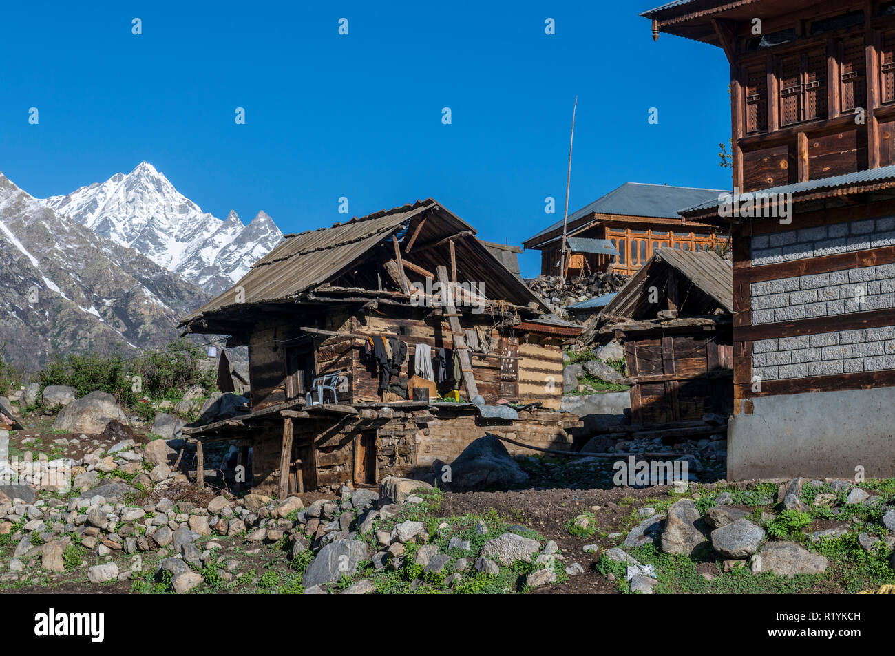 Holzhäuser des Chitkul, das letzte Dorf von Sangla Valley, bei 3.400 m entfernt, umgeben von schneebedeckten Bergen Stockfoto