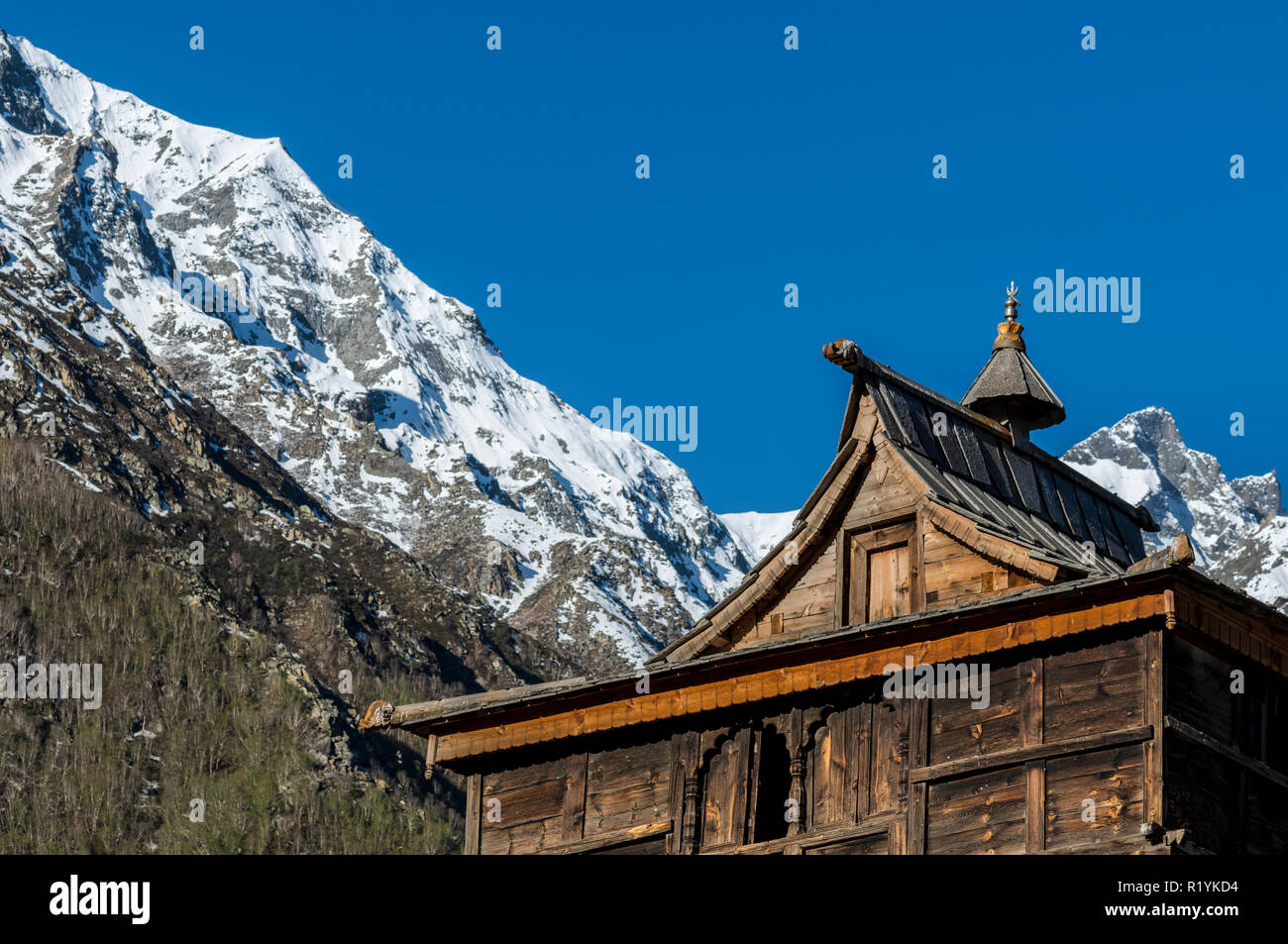 Holzhäuser des Chitkul, das letzte Dorf von Sangla Valley, bei 3.400 m entfernt, umgeben von schneebedeckten Bergen Stockfoto