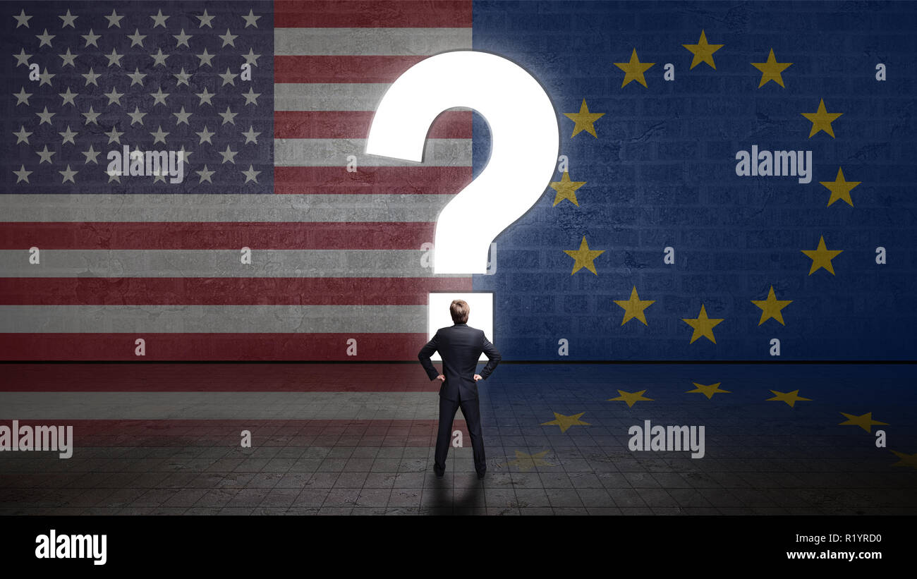 Unternehmer stehen vor einer Wand mit einem Fragezeichen und die Flaggen der USA und der Europäischen Union Stockfoto