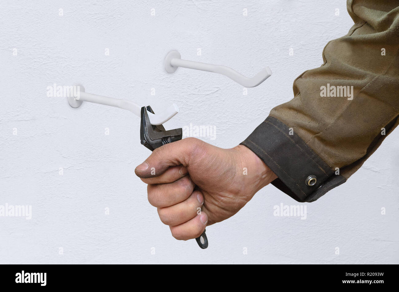 Eine Arbeitsgruppe Klempner mounts Spannen für den Kühler an der Wand. Close-up. Stockfoto