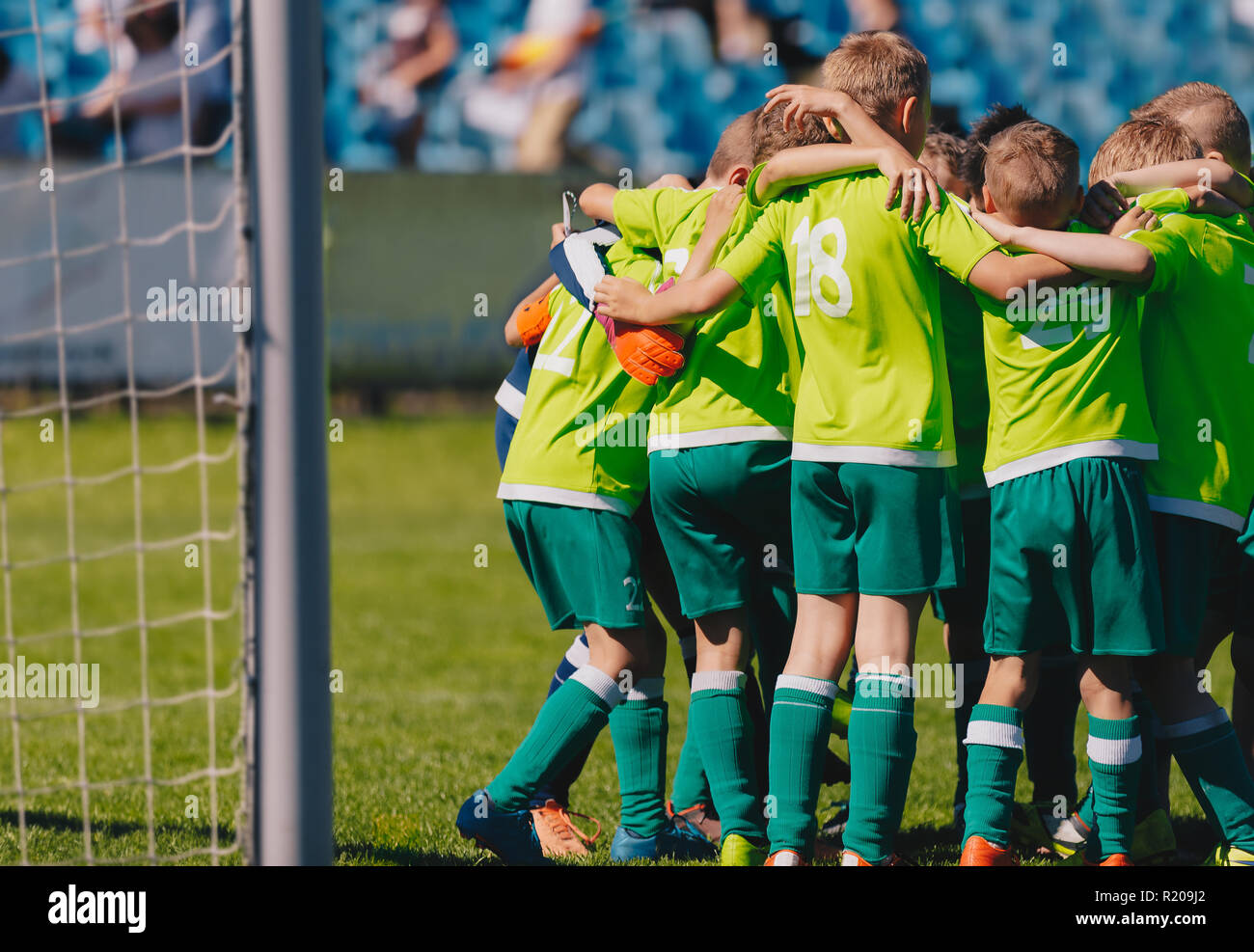 Gruppe Porträt der Jungen Fußballmannschaft. Fußball Huddle Bild. Kinder- Fußball-Mannschaft auf dem Spielfeld. Fußball-Stadion im Hintergrund. Stockfoto