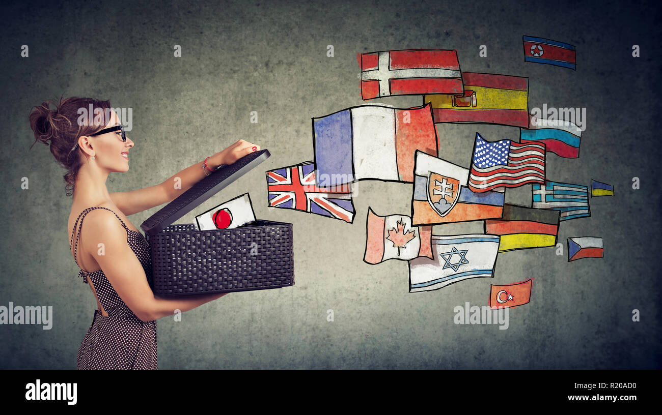 Junge Frau spricht verschiedene Sprachen Öffnen einer mit internationalen Flaggen Weg fliegen Stockfoto