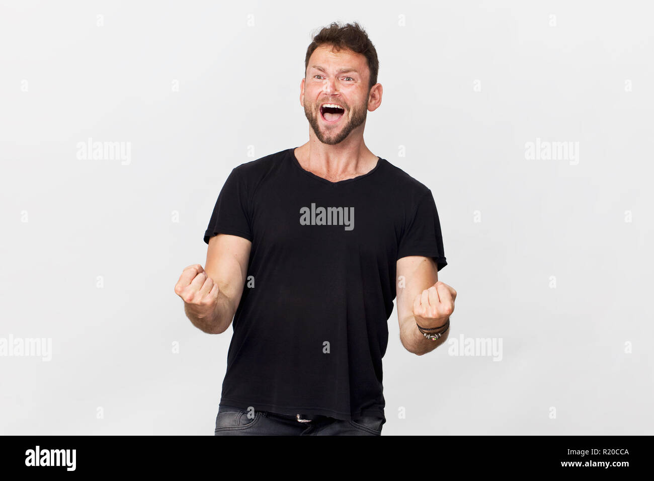 Glückliche junge Mann lächelnd portrait Sieg Geste gegen den weißen Hintergrund Stockfoto