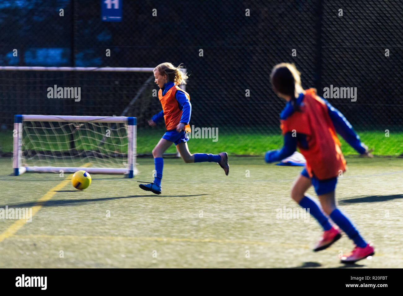 Mädchen Laufen, Fußball spielen auf dem Feld Stockfoto