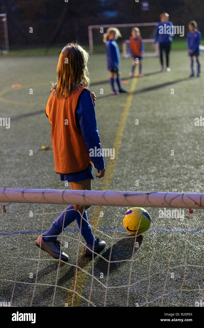 Mädchen Fußball-Spieler üben am Feld in der Nacht Stockfoto