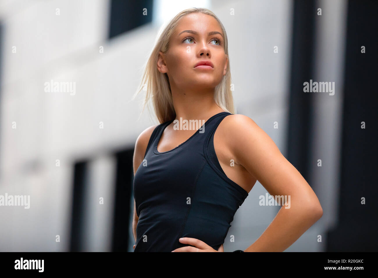 Der Portrati zuversichtlich Fitness Frau in Workout Outfit in Stadt stehend Stockfoto