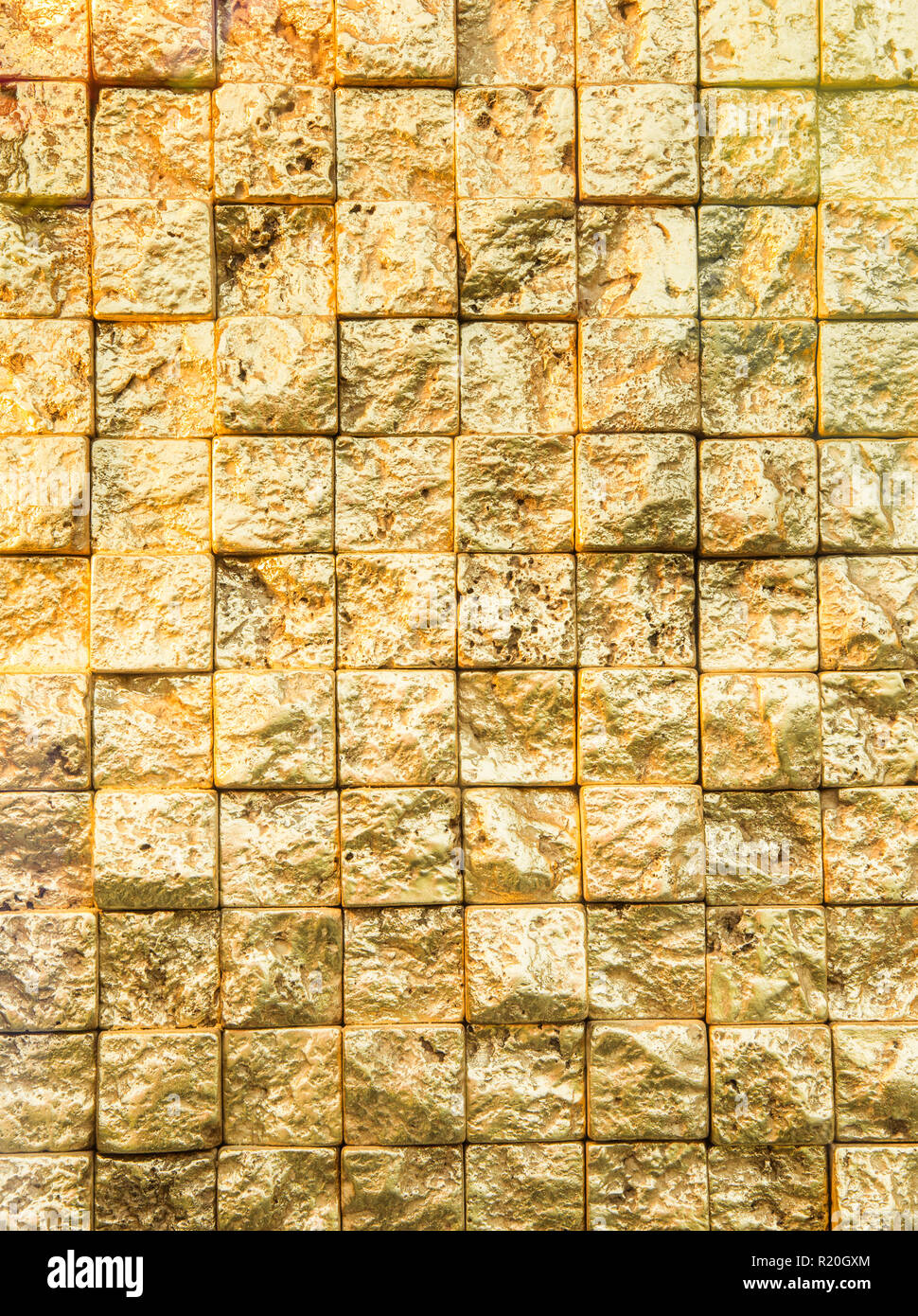 Holprige golden klein, sogar Plätze Mauer Hintergrund. Stockfoto