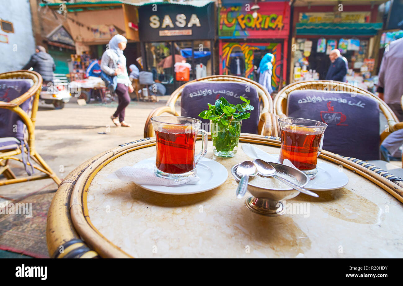 Kairo, Ägypten - Dezember 21, 2017: ein Glas heißer schwarzer Tee genießen, mit frischer Minze im Außenbereich Teehaus, in belebten Al Khayama Straße, Trade Boxes Stockfoto