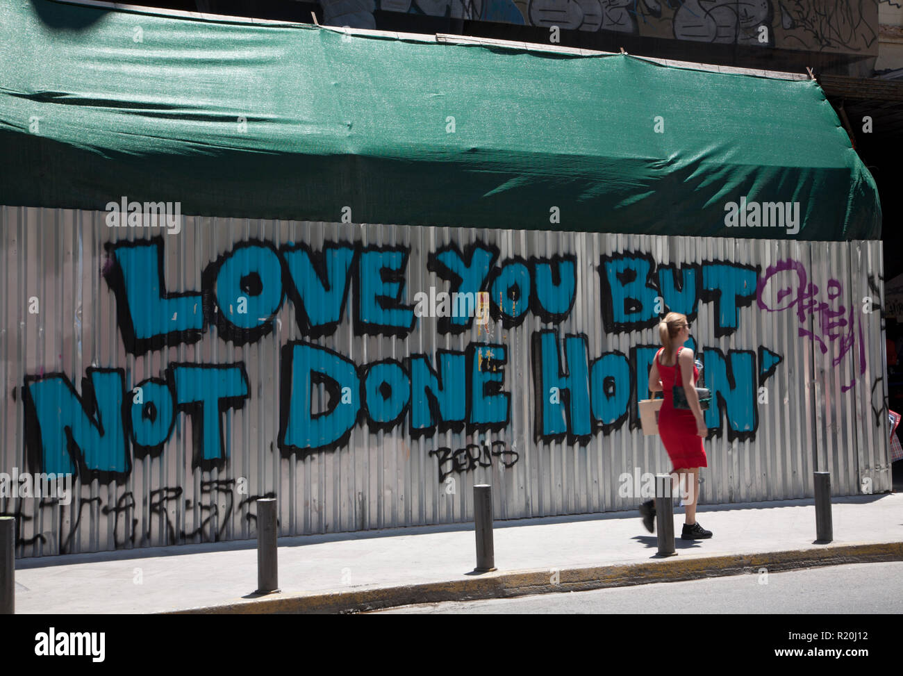 Frau in Rot walking Hintergrund Graffiti athinas monastiraki Athen Griechenland Stockfoto