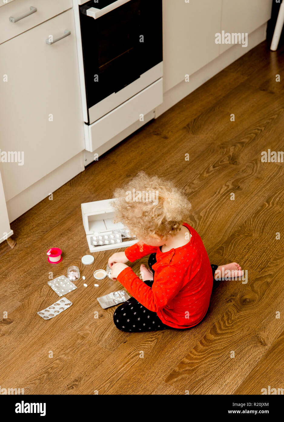 Junge Kind spielen alleine mit Pillen Tabletten auf Home Küche Etage. Von Kindern fernhalten Konzept erreichen. Keine Medizinschrank. Stockfoto