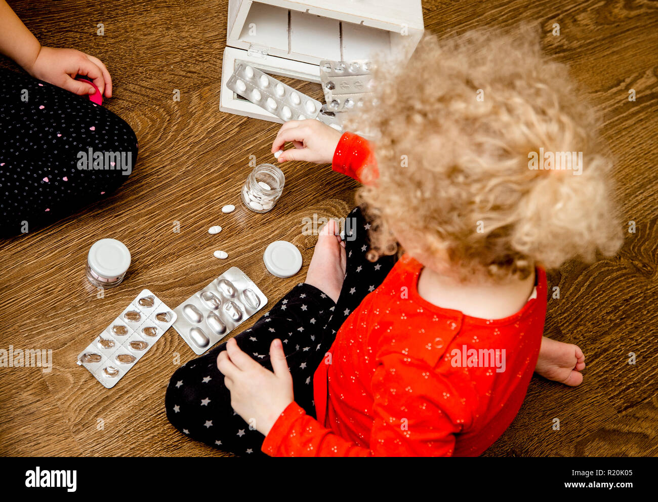 Junge Kind spielen alleine mit Pillen Tabletten auf Home Küche Etage. Von Kindern fernhalten Konzept erreichen. Keine Medizinschrank. Stockfoto