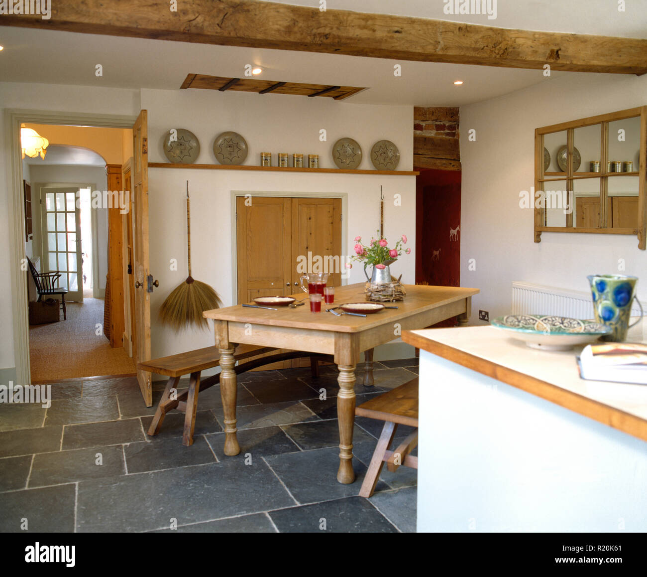 Einfache Holz- Tisch und Bank im Land Küche mit Schieferboden Stockfoto