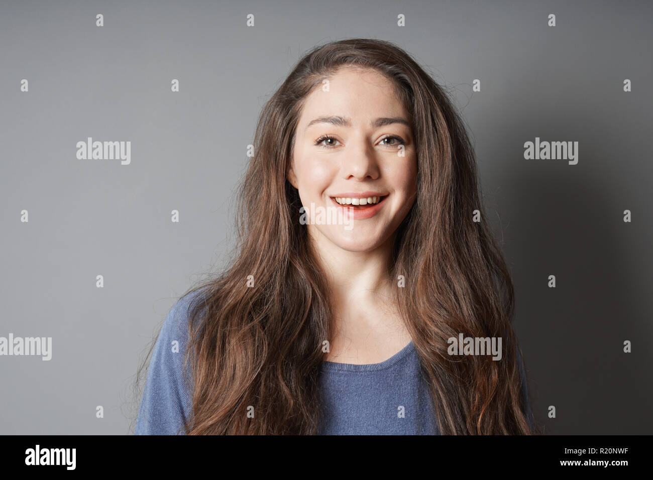 Glückliche junge Frau in ihrem 20s mit großen toothy Lächeln Stockfoto