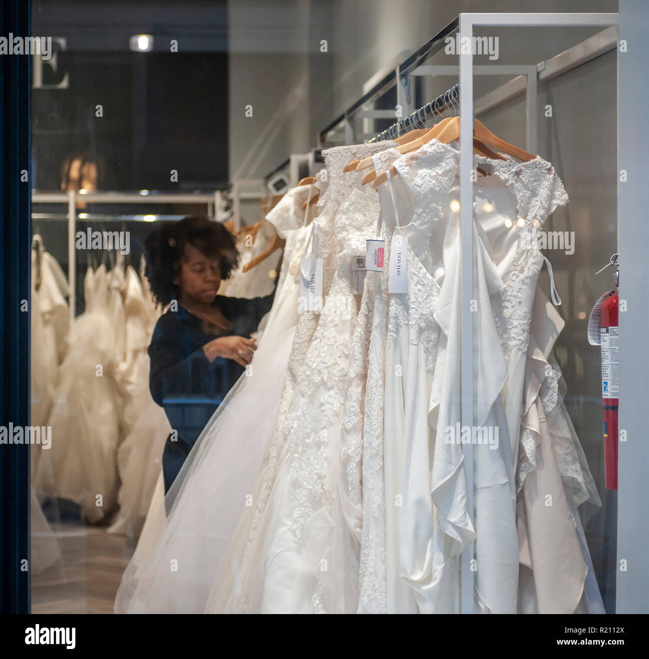 Ein Mitarbeiter ordnet Kleider in einem David Bridal Store im New Yorker Stadtteil Chelsea am Sonntag, 11. November 2018. Davids Bridal der gemeldet werden soll, Vorbereiten einer Kapitel 11 Konkurs, wenn es nicht ein Abkommen mit seinen Gläubigern zu erreichen. Das Unternehmen hat bis zum 14. November die Zinszahlung auf etwa $ 760 Mio. in Schulden zu machen. (© Richard B. Levine) Stockfoto