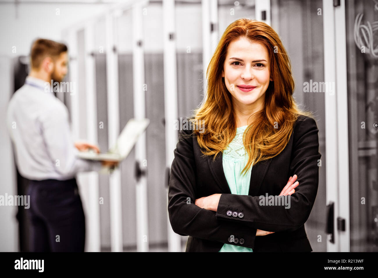 Techniker stehen mit verschränkten in einem Serverraum Stockfoto