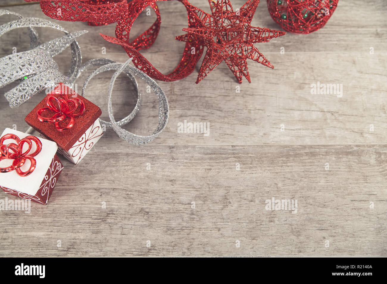 Rote und weiße Weihnachten Pakete mit glitzerndem Band und Dekorationen auf Grau rustikal Holz Tisch Stockfoto