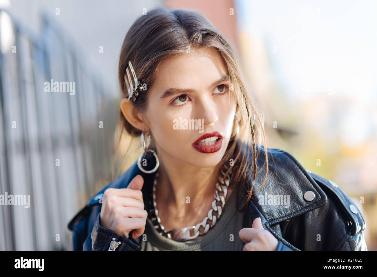 Foto Modell mit hellen Lippen tragen massive Ohrringe und Halskette Stockfoto