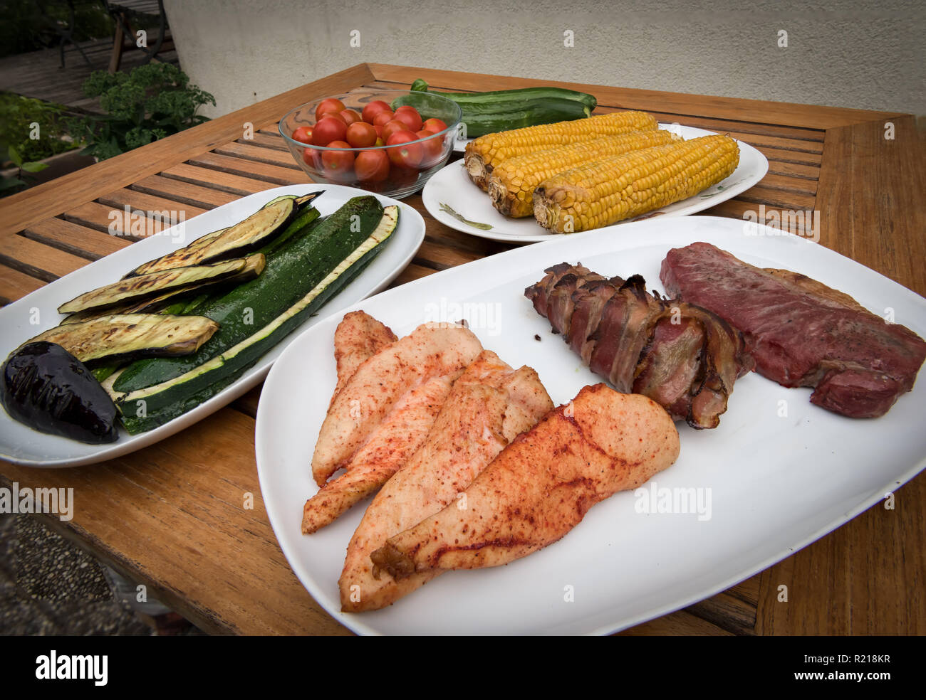 Verschiedene leckere Gerichte (Schwein, Rind, Huhn, Gemüse) in einem  Barbecue smoker stehend auf einem hölzernen Tisch zubereitet  Stockfotografie - Alamy