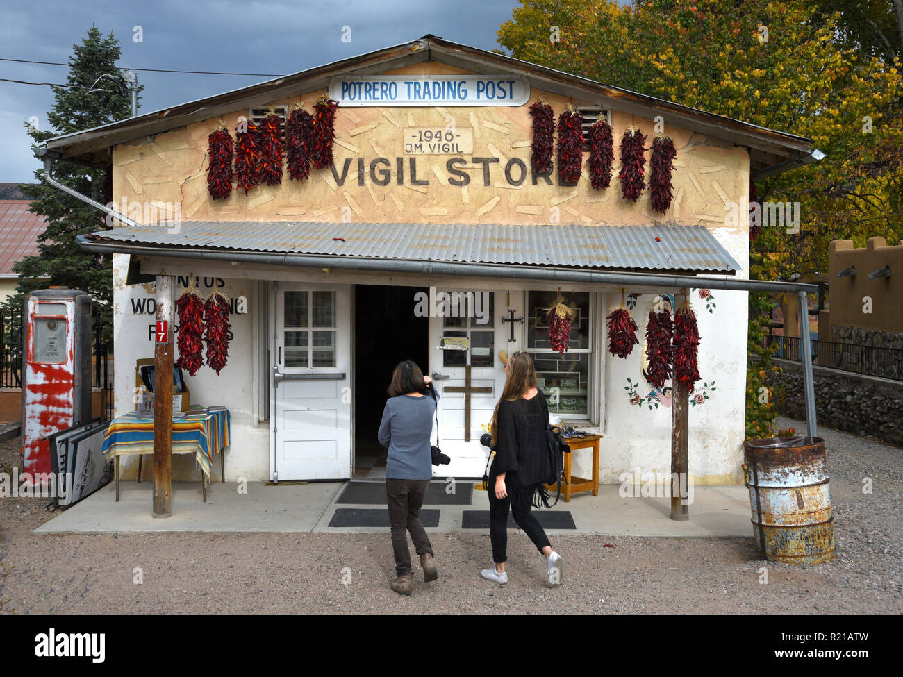 Zwei Touristen geben Sie einen Store in Messancy, New York USA. Strings getrockneter Chile peppers, oder ristras, hang in Front. Stockfoto