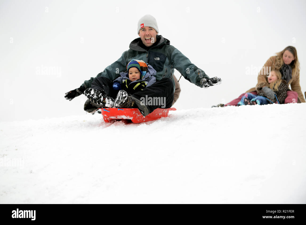 Vater und Sohn Rodeln in Shropshire Winterszene Großbritannien Familien Rodeln auf Ironbridge 2017 Personen Kinder schneien Stockfoto
