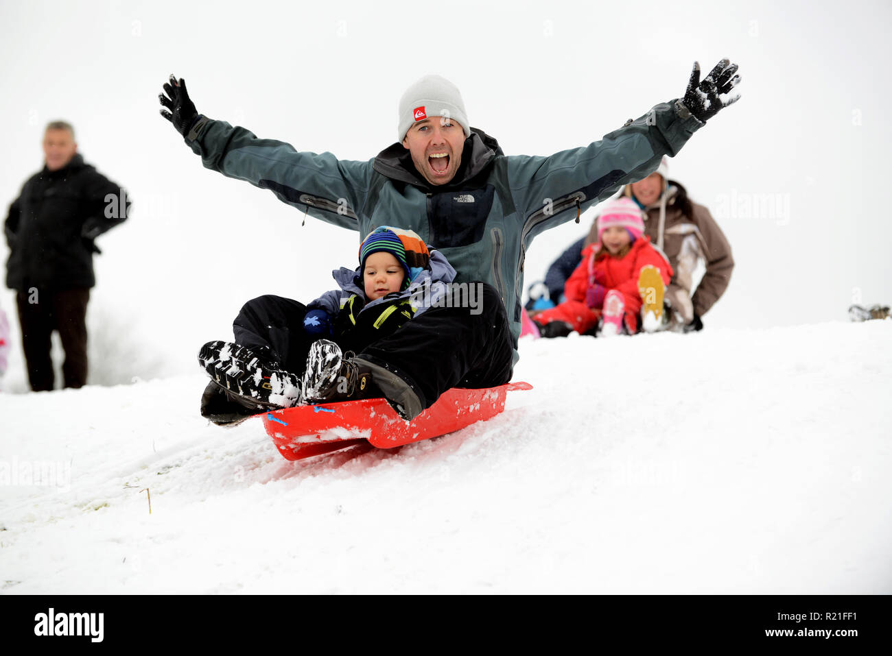 Vater und Sohn Rodeln in Shropshire Winterszene Großbritannien Familien Rodeln auf Ironbridge 2017 Personen Kinder schneien Stockfoto