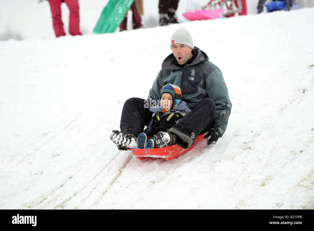 Vater und Sohn Rodeln in Shropshire Winterszene Großbritannien Familien Rodeln auf Ironbridge 2017 Personen Kinder schneien Stockfoto
