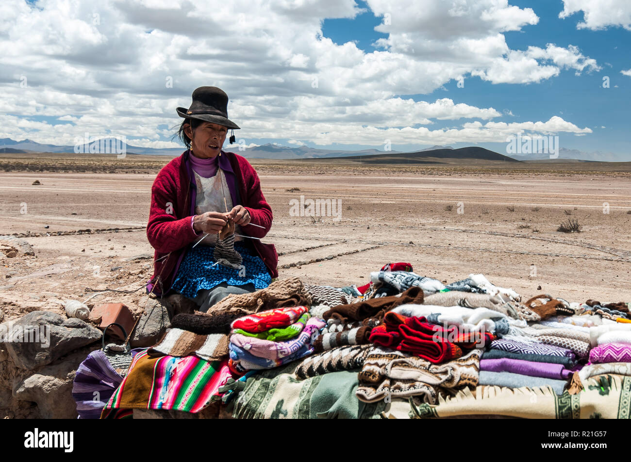 Peru und Bolivien Menschen im Alltag. 2013.EINE Frau in bolivianischem Outfit und Melone Hut verkauft Schals, Pullover, Stockfoto