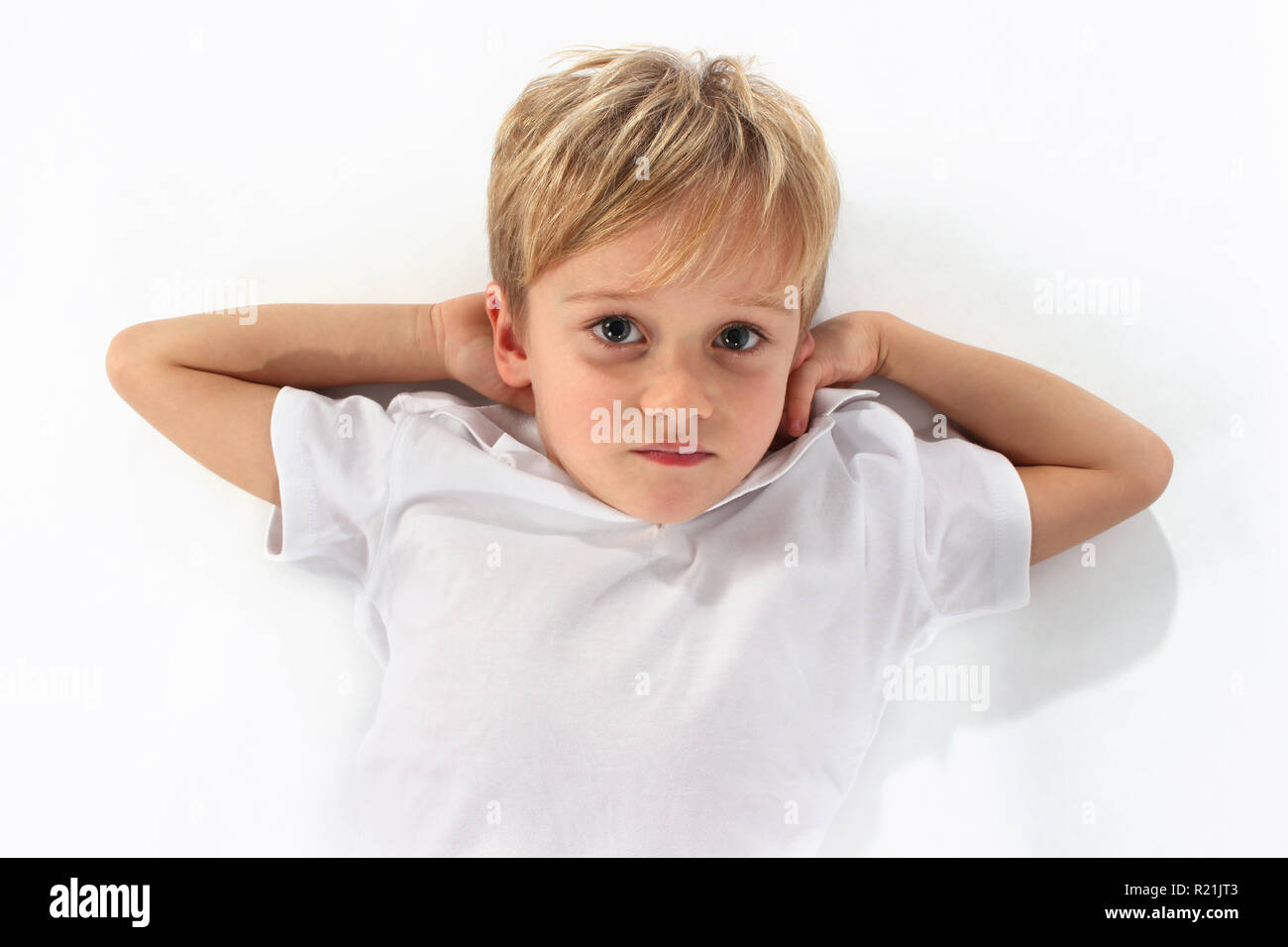Adorable niedlichen kleinen Jungen mit seinen Armen liegend gestreckt Stockfoto