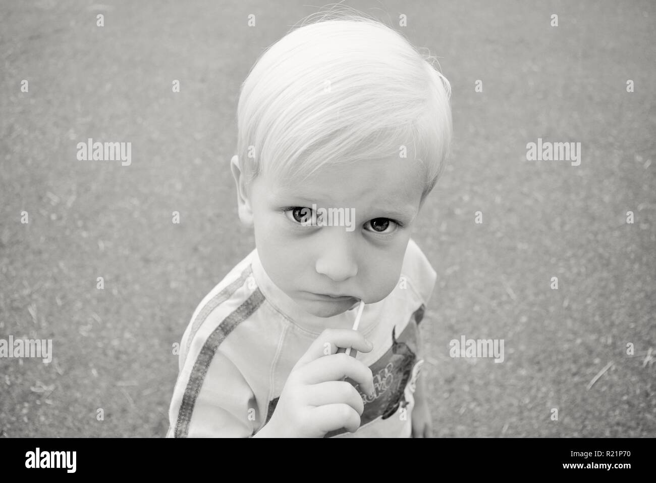 Little Boy Essen Lolly Pop in Schwarz und Weiß Stockfoto