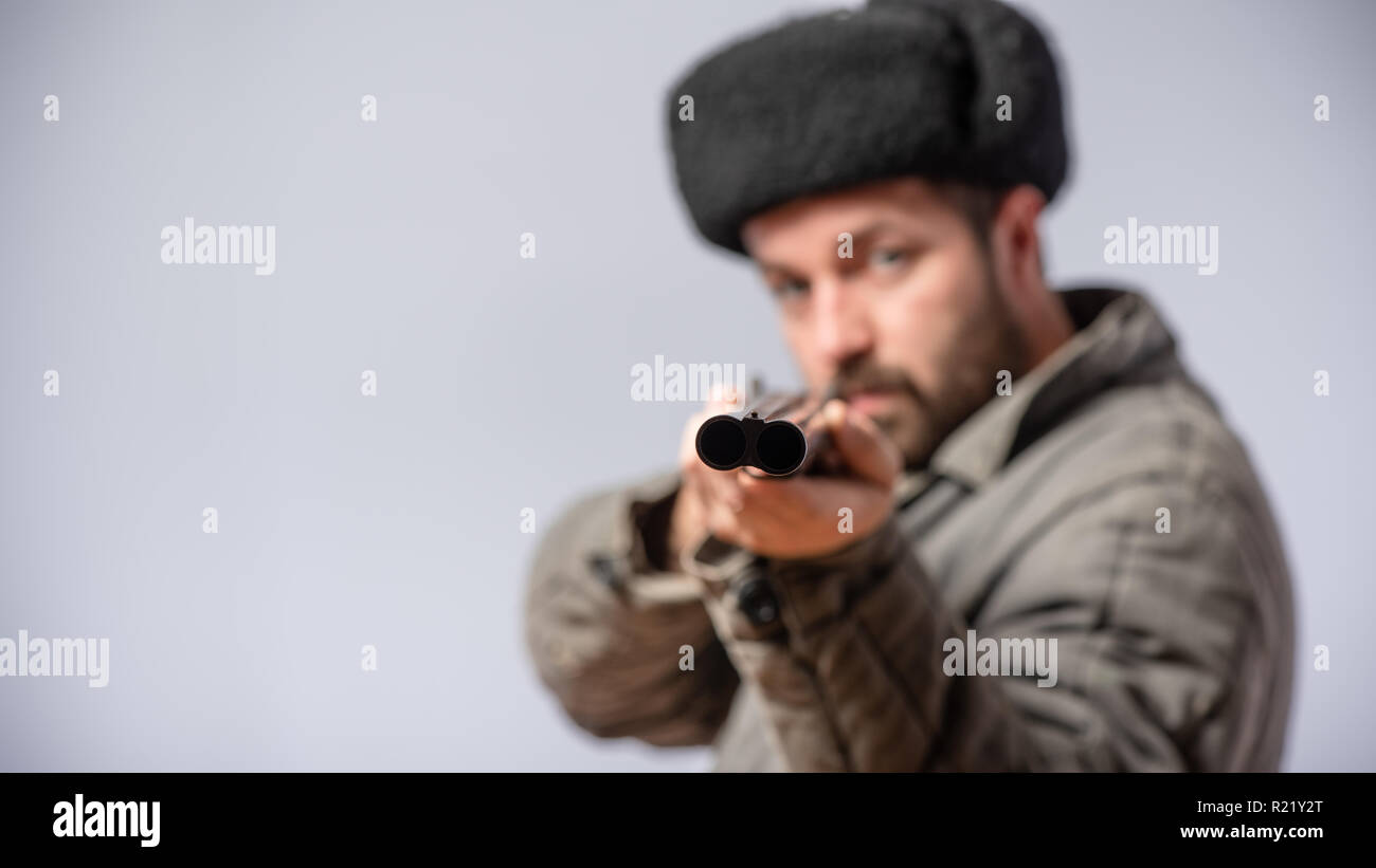 Jäger mit horizontalen doppelläufige Schrotflinte in der Hand, Gewehr ist vorwärts gerichtet, retro style, Studio shot Stockfoto