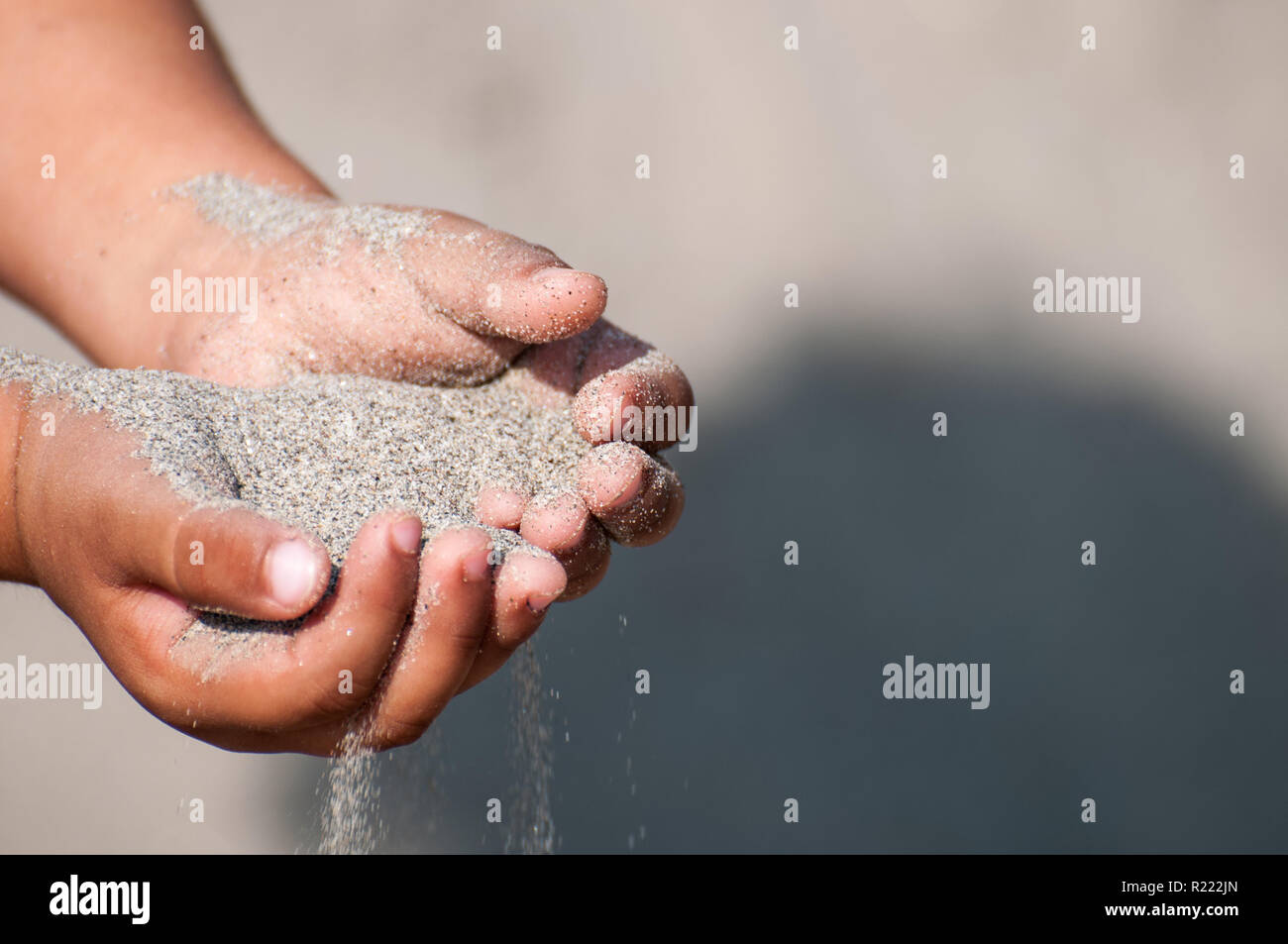 Sand in der Hand am Strand Stockfoto