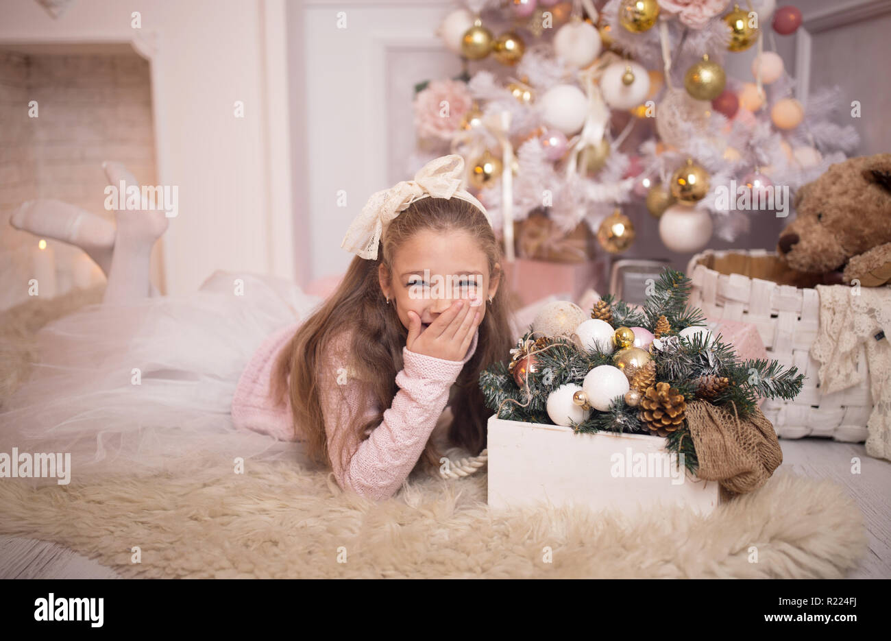 Frohe Weihnachten feiern. Schöne Mädchen in einem Kleid liegen in der Nähe der Weihnachtsbaum. Winterurlaub. Frohes neues Jahr. Stockfoto