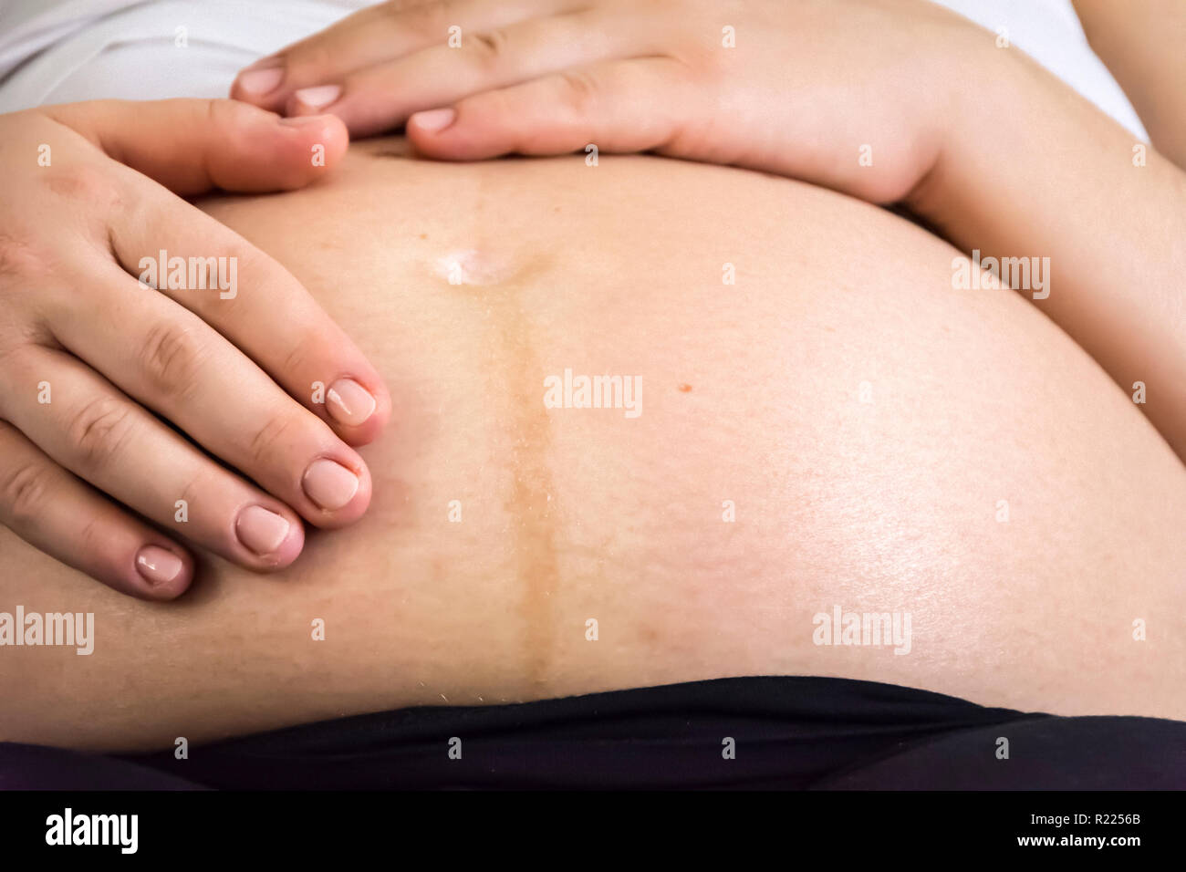 Hände einer schwangeren Frau, Ihren Bauch streicheln. Neues Leben Konzept Stockfoto