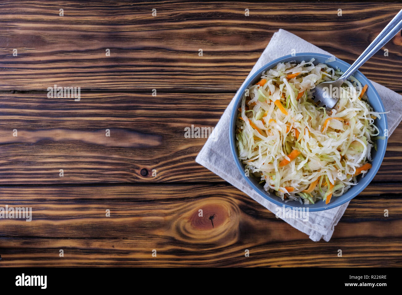 Schüssel mit Sauerkraut und die Gabel am Tisch Stockfoto