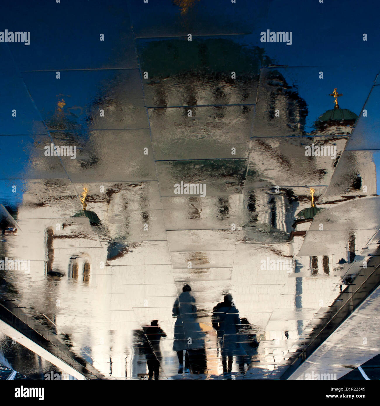 Unscharfe Reflexion des Heiligen Sava orthodoxer Tempel und einige Leute nähern, auf Nasser City Pflaster in Belgrad, Serbien Stockfoto