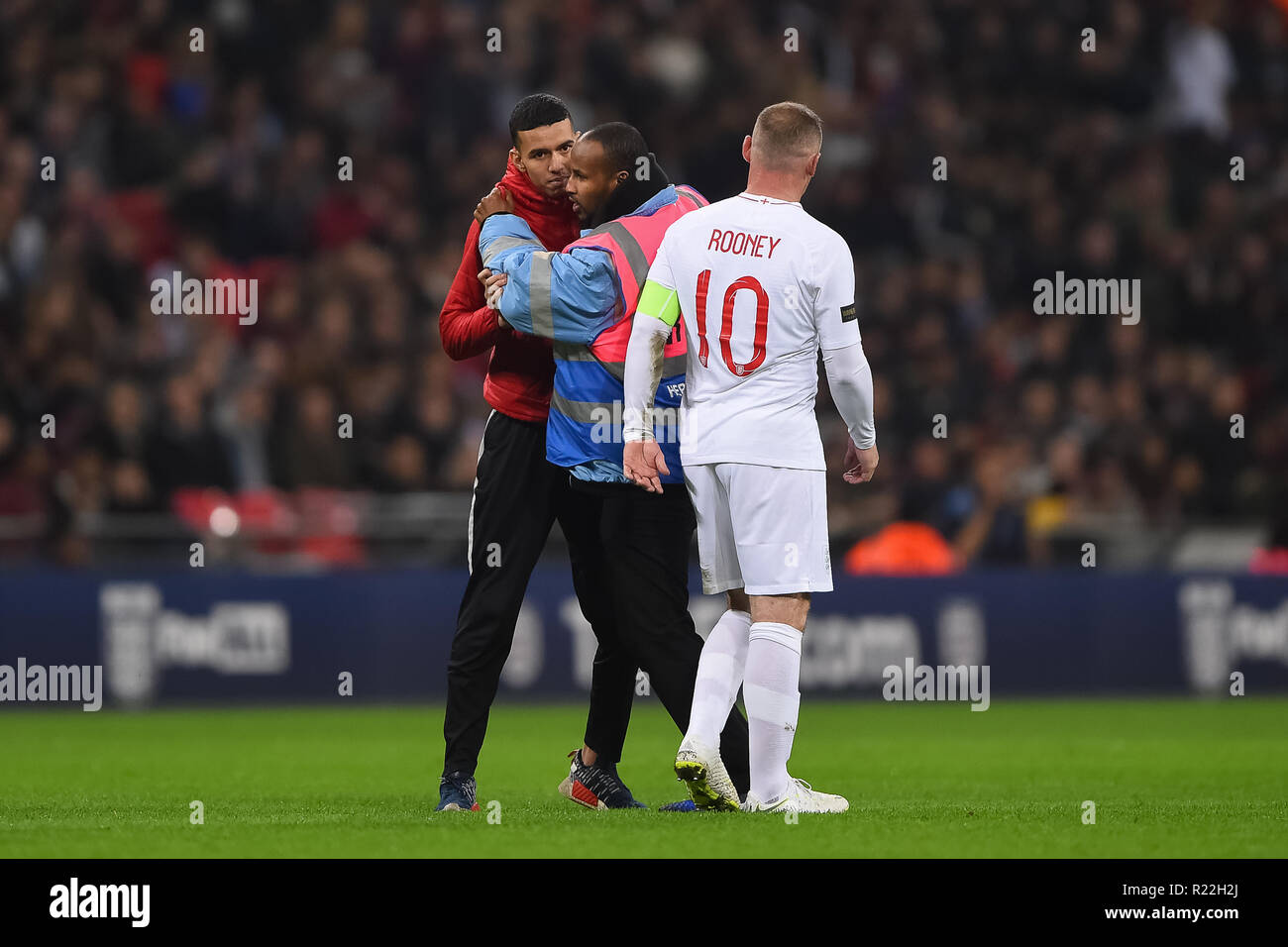 London. Vereinigtes Königreich. 15. November 2018. Wembley Sicherheit ringt mit Anhänger, nachdem er nach England lief vorwärts Wayne Rooney (10) während der internationalen Freundschaftsspiel zwischen England und USA im Wembley Stadion. Credit: MI Nachrichten & Sport/Alamy leben Nachrichten Stockfoto