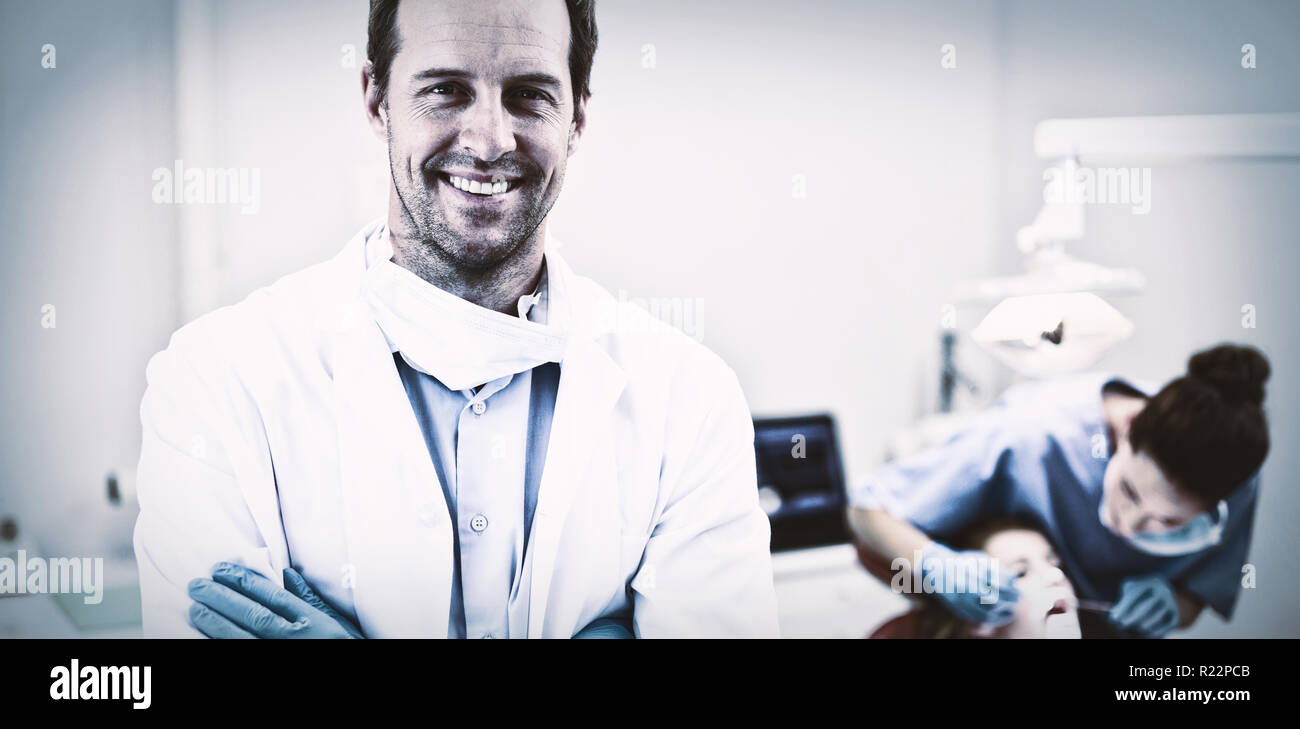 Zahnarzt stehend mit der Waffe in der Klinik gekreuzt Stockfoto