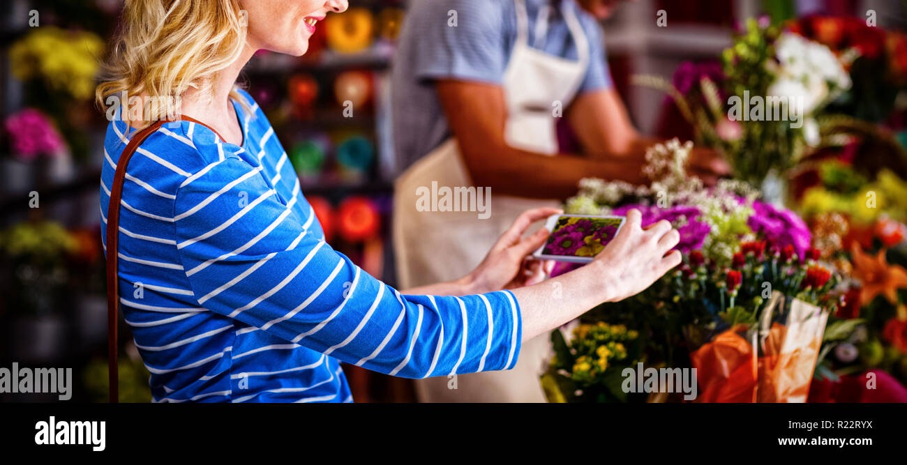 Frau nehmen Foto von Blumenstrauß Stockfoto