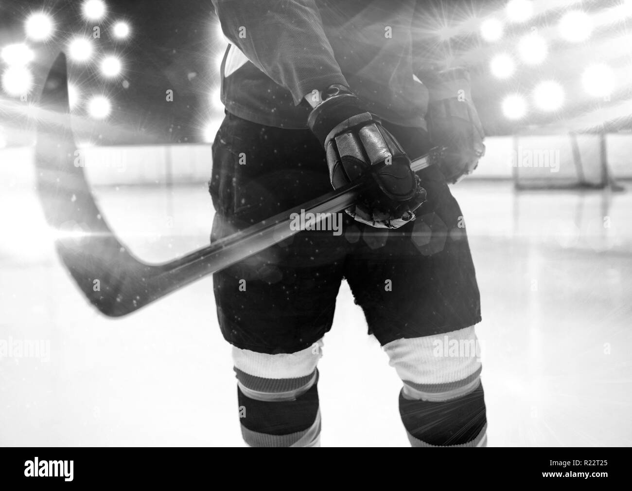 Das zusammengesetzte Bild im mittleren Abschnitt des Hockey Spieler mit Stick Stockfoto