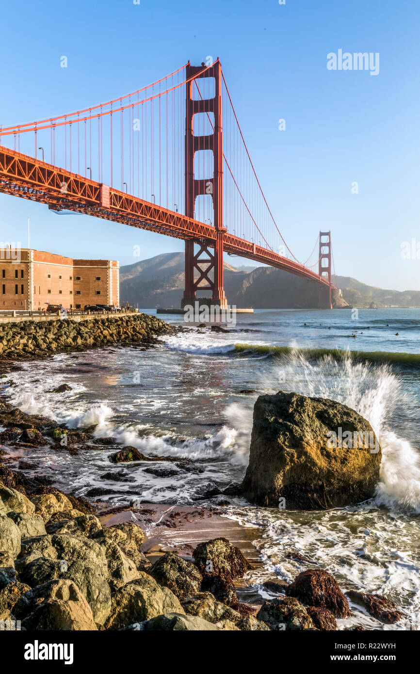 Surfers fangen früh morgens Wellen unter der Golden Gate Bridge in der Nähe von Fort Point bei der Eröffnung der San Francisco Bay an den Pazifischen Ozean. Stockfoto