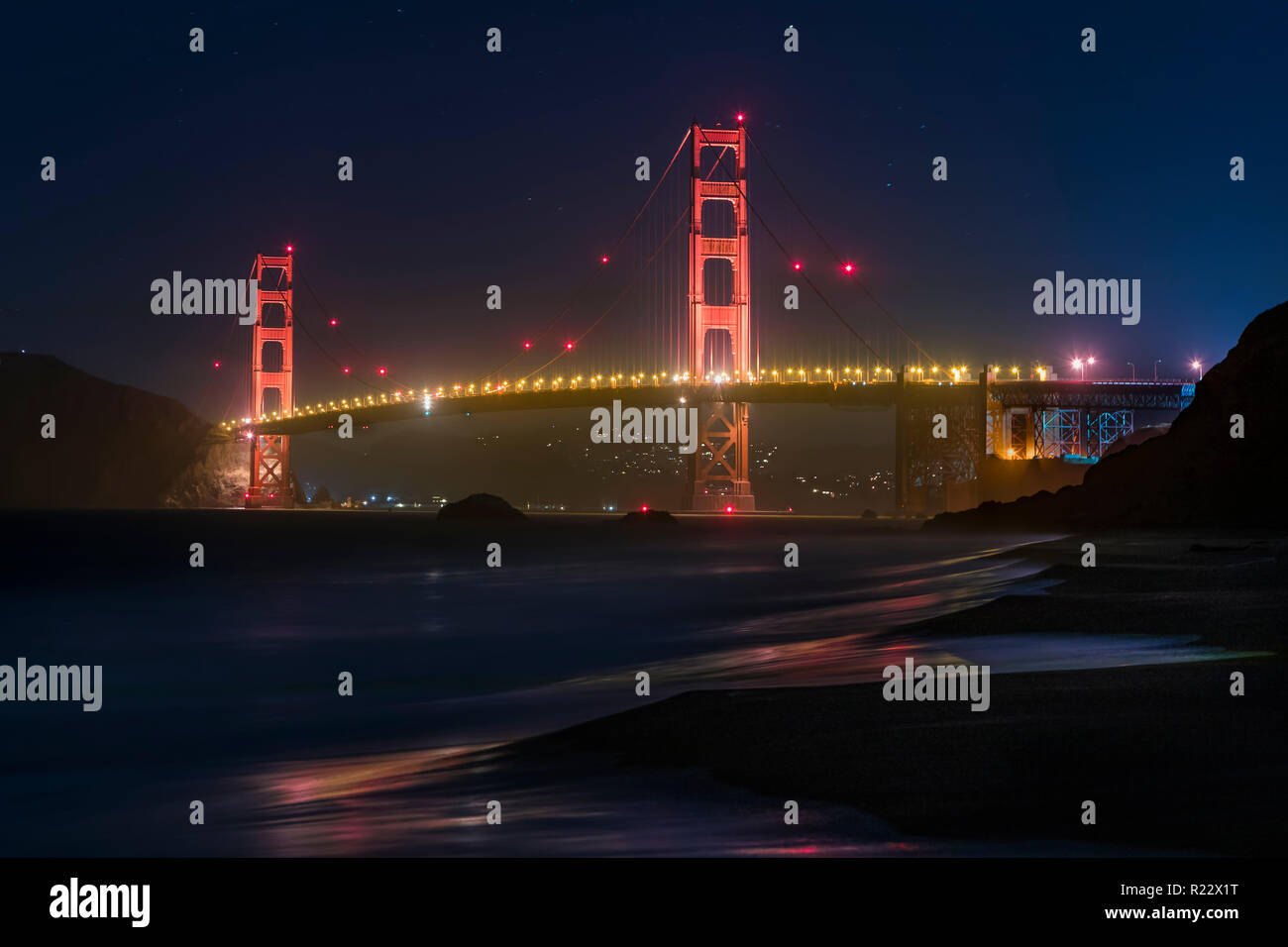Wahrzeichen von San Francisco Golden Gate Bridge ist von Baker Beach nach Einbruch der Dunkelheit gesehen. Stockfoto