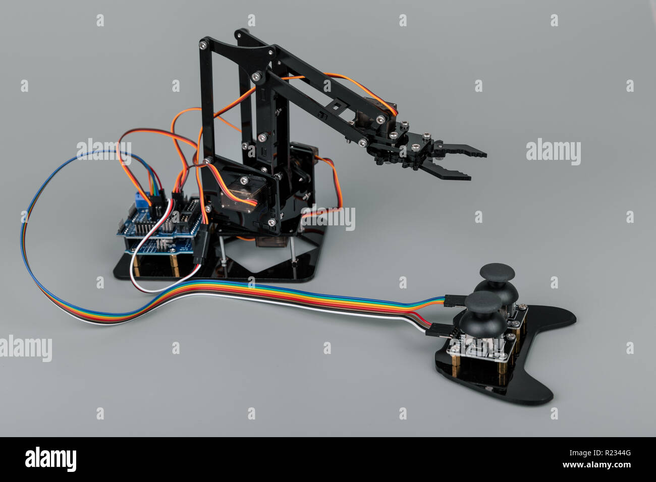 Kleine Roboterarm mit Joystick auf grauem Hintergrund Stockfoto