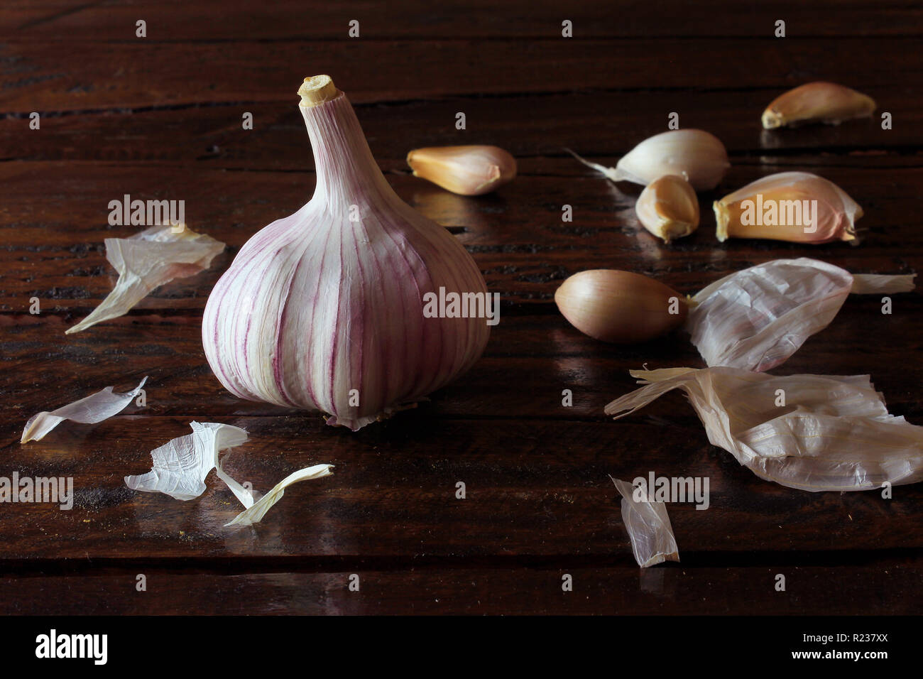 Knoblauch Zwiebeln auf rustikalen Holztisch ausgebreitet. Nahaufnahme von Knoblauch Zwiebeln. Stockfoto