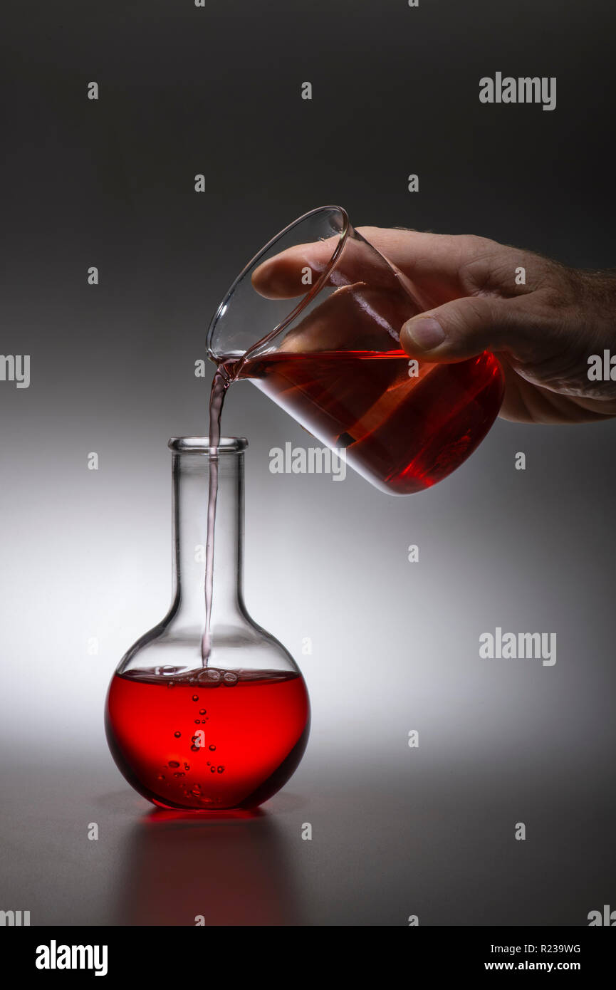 Hand Poring rote Flüssigkeit in der Chemie Experiment Stockfoto