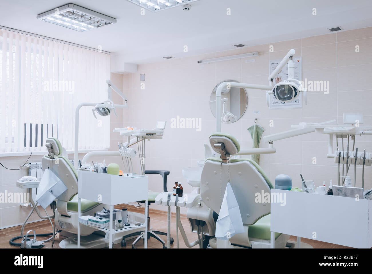 Zahnmedizinische Klinik interior design mit mehreren Zahnarztstuhl und Werkzeuge. Moderne Zahnarztpraxis Büro mit grünen Stühlen. Zahnarztpraxis. Weißer Ton. Stockfoto