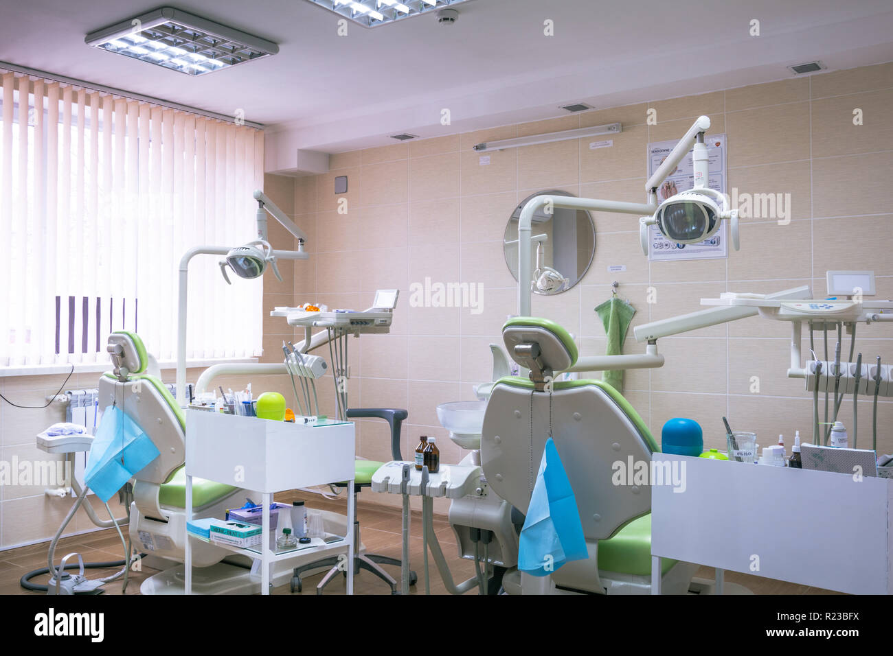 Zahnmedizinische Klinik interior design mit mehreren Zahnarztstuhl und Werkzeuge. Moderne Zahnarztpraxis Büro mit grünen Stühlen. Zahnarztpraxis. Stockfoto
