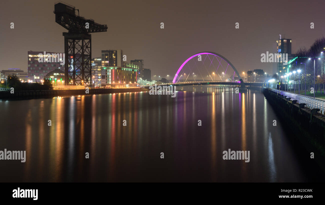 Glasgow, Schottland, Großbritannien - 5 November, 2018: den Fluss Clyde Clyde Arc fließt unter der Brücke und vorbei an den Sehenswürdigkeiten Finnieston Kran in der Nacht in Glasgow. Stockfoto