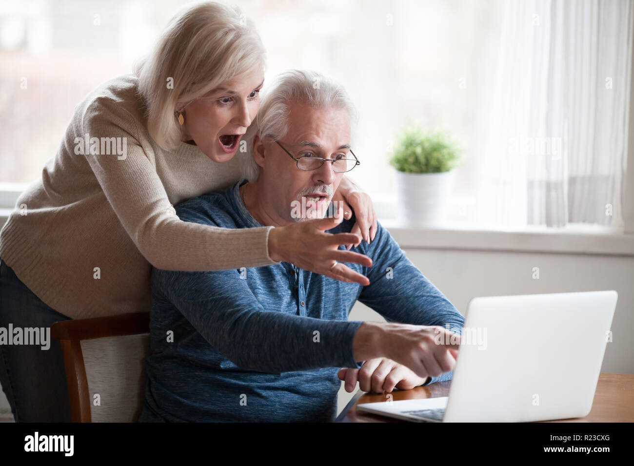 Älterer Mann und Frau an Laptop Bildschirm sehen unglaublich Informationen zeigen schockiert, im Alter von Paar beachten Sie unerwartete auf Computer überrascht, elderl Stockfoto